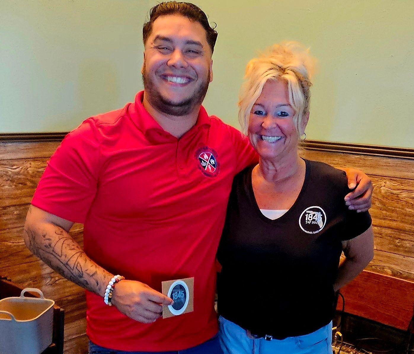 A man in a red shirt is standing next to a woman in a black shirt.