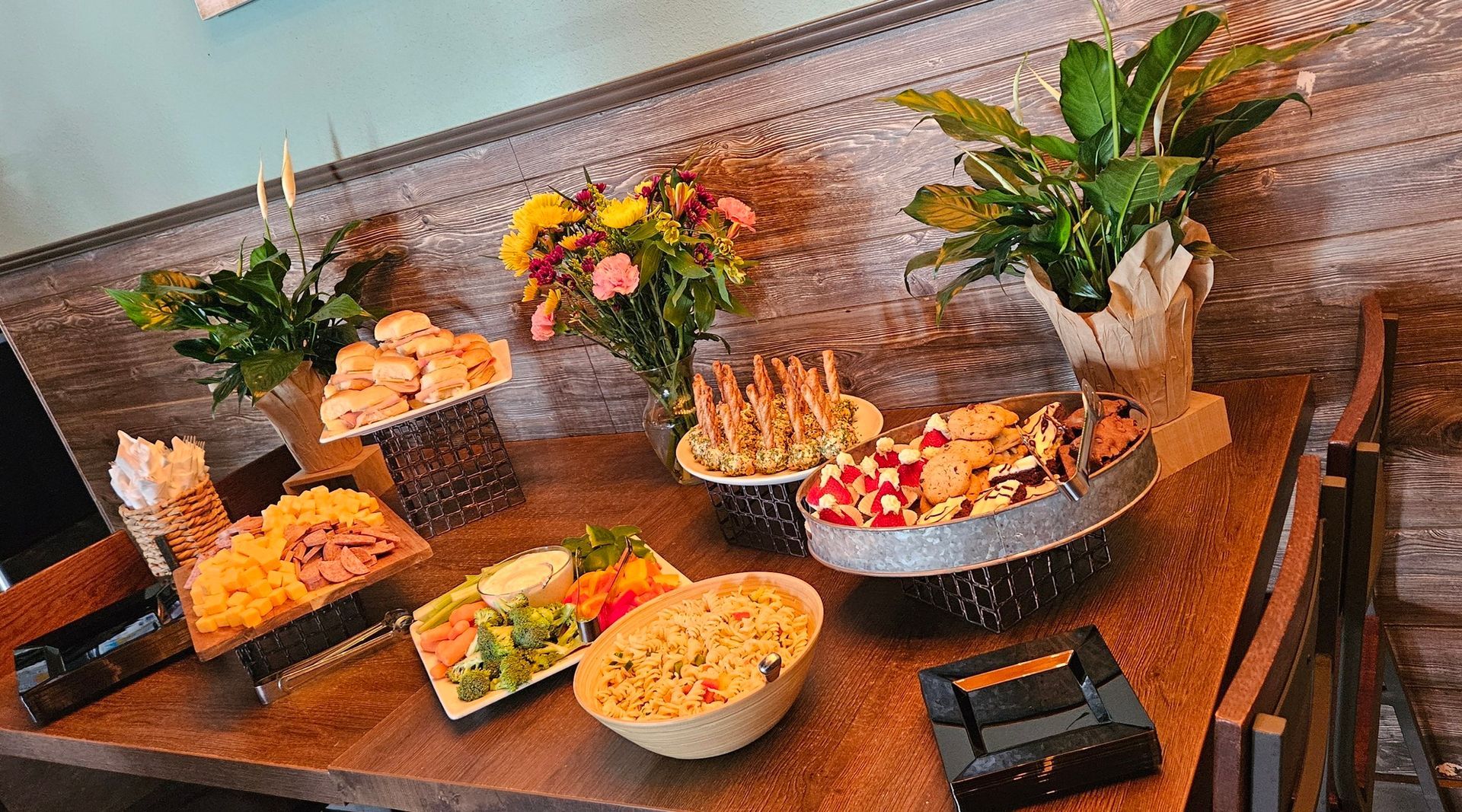 A wooden table topped with bowls of food and flowers.