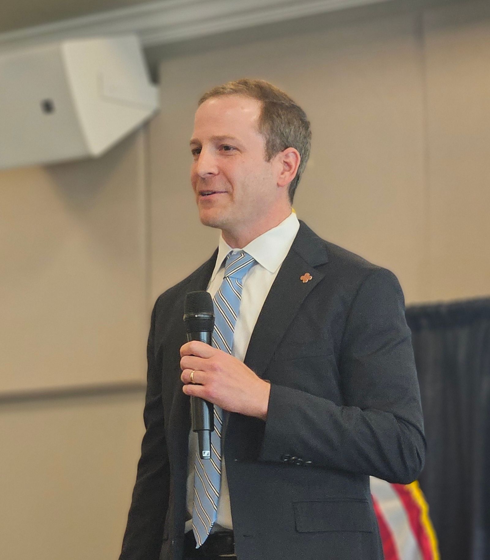 A man in a suit and tie is holding a microphone