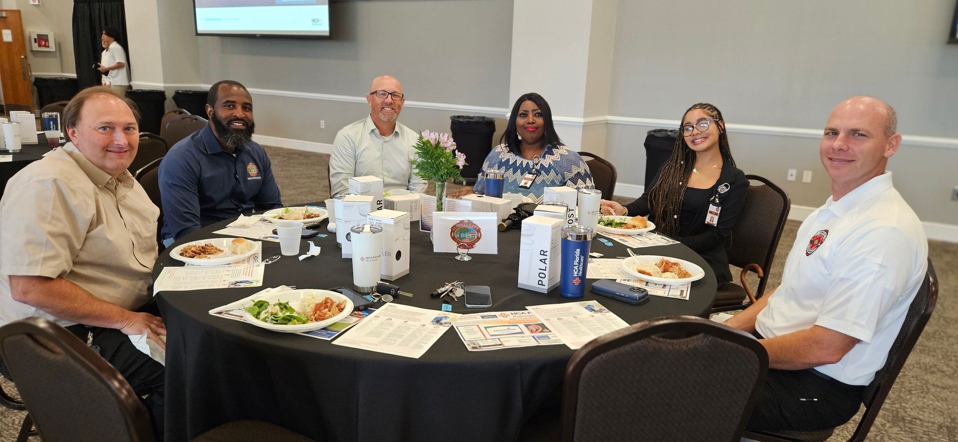 A group of people are sitting around a table with food on it.