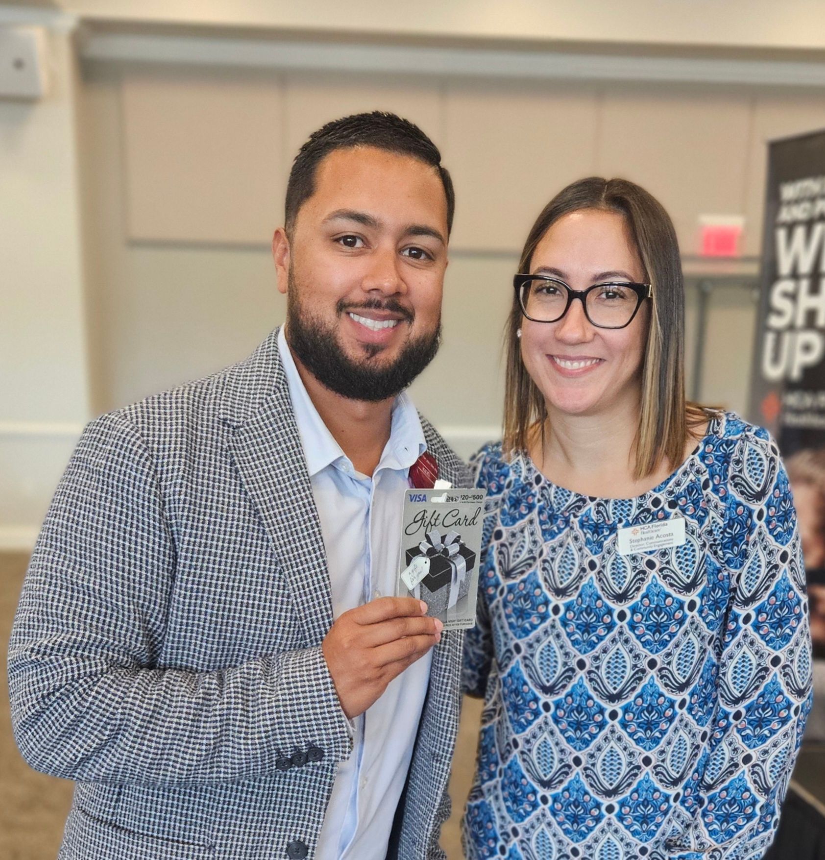 A man and a woman are posing for a picture and the woman is wearing glasses