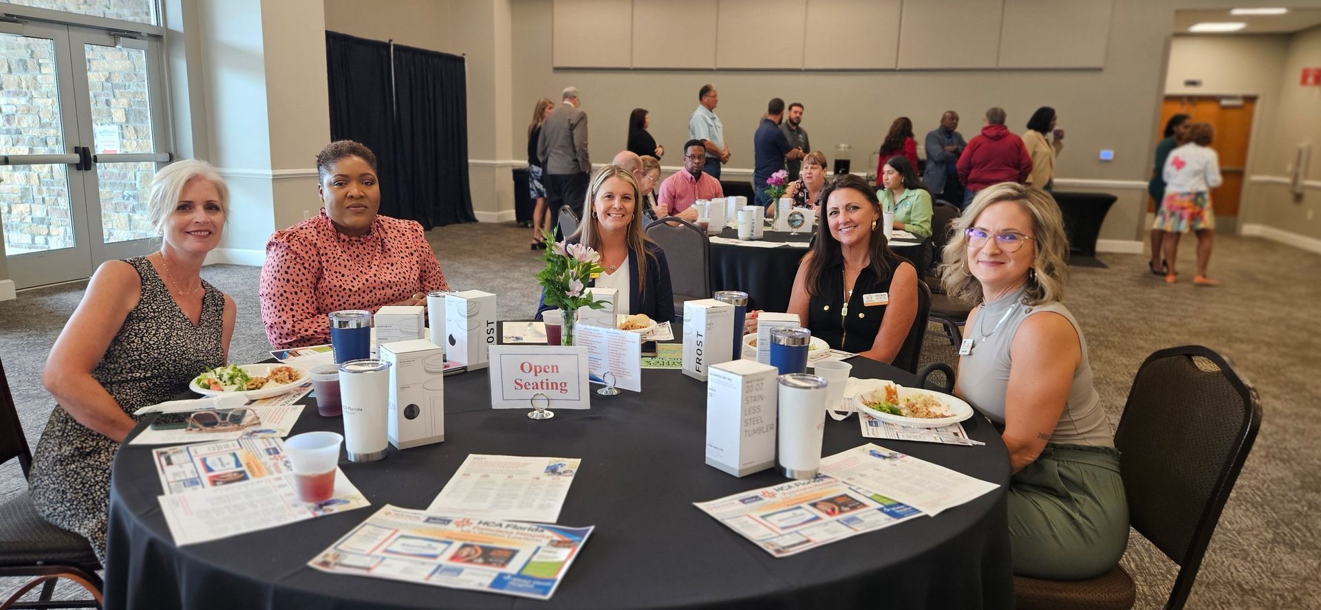 A group of women are sitting at a table in a room.