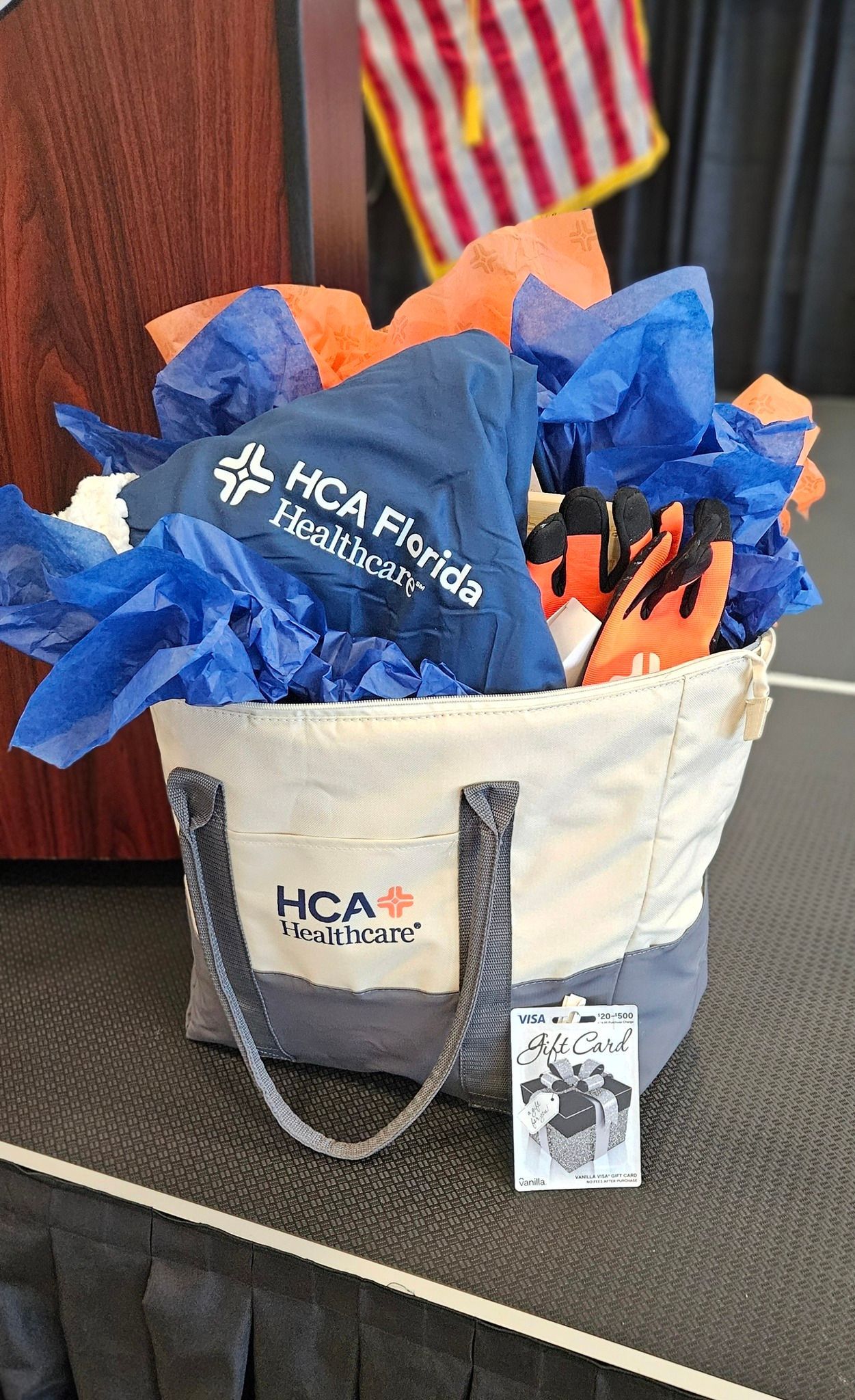 A basket filled with blue and orange tissue paper and umbrellas.