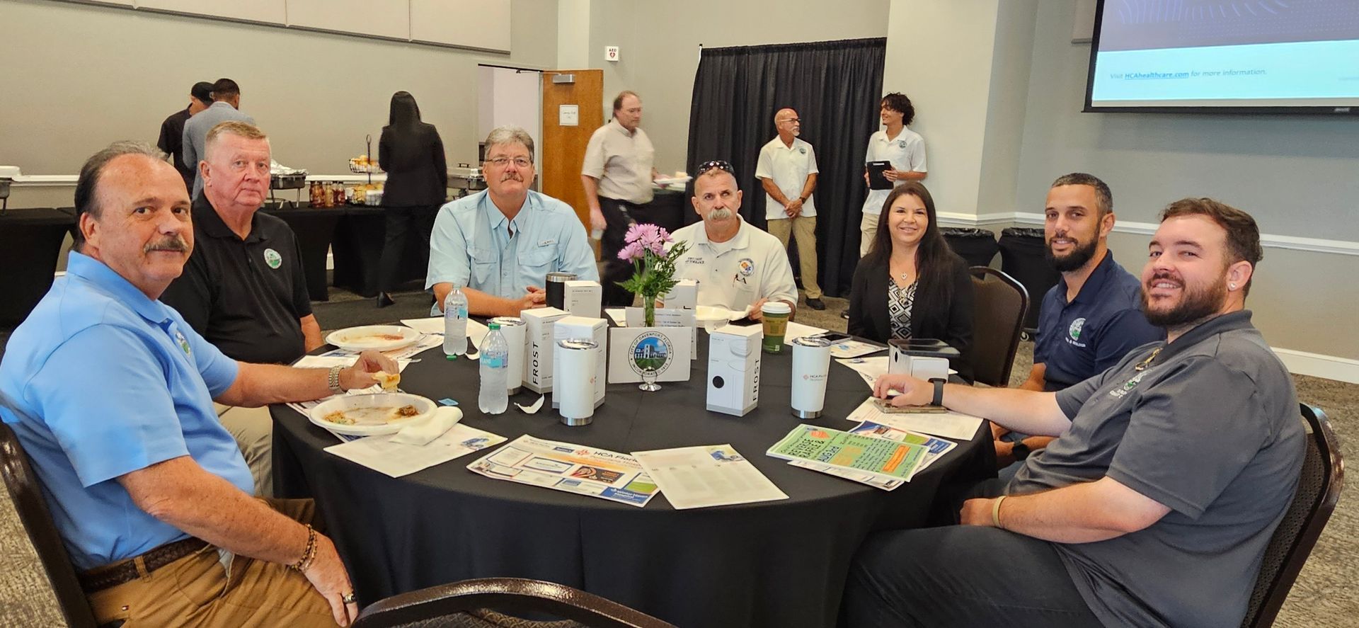 A group of people are sitting around a table in a room.