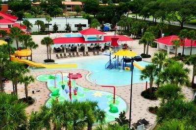 An aerial view of a water park surrounded by palm trees and buildings.