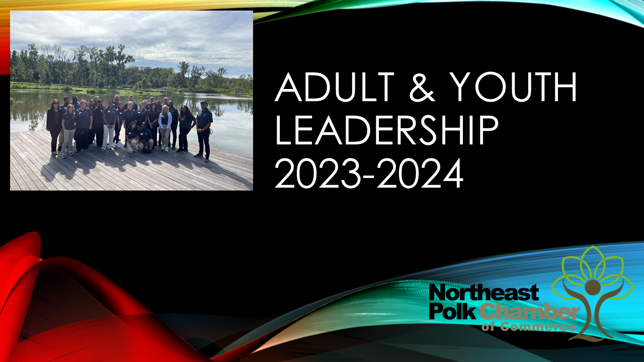 A group of people are standing on a dock next to a lake.