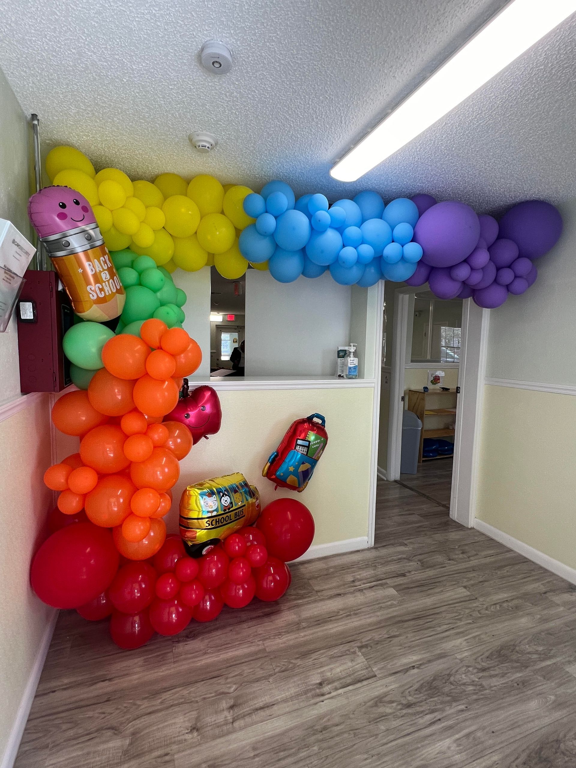 A bunch of balloons are hanging from the ceiling in a room.