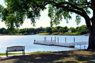 A lake with a dock and a bench in the foreground