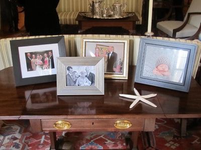 A table with four framed pictures and a starfish on it