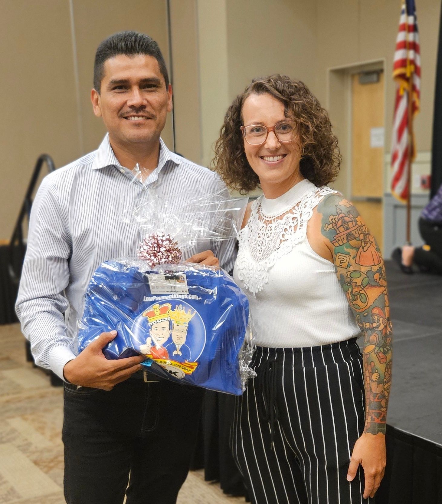 A man and a woman are standing next to each other holding a blue bag