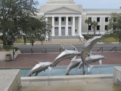 A fountain with dolphins in front of a building