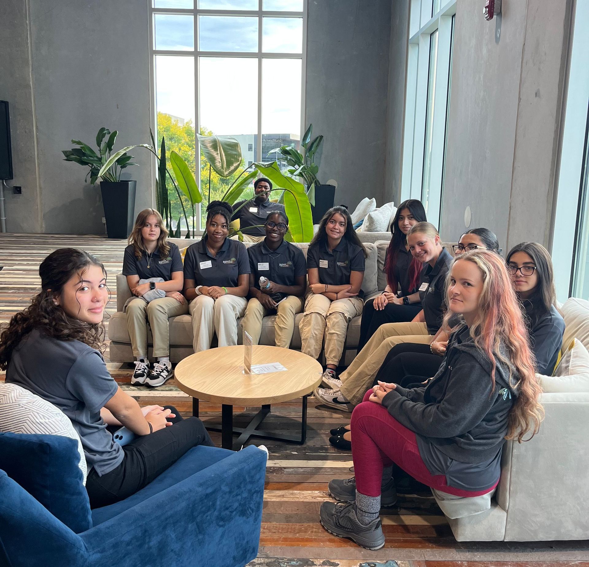 A group of people are sitting around a table in a living room.