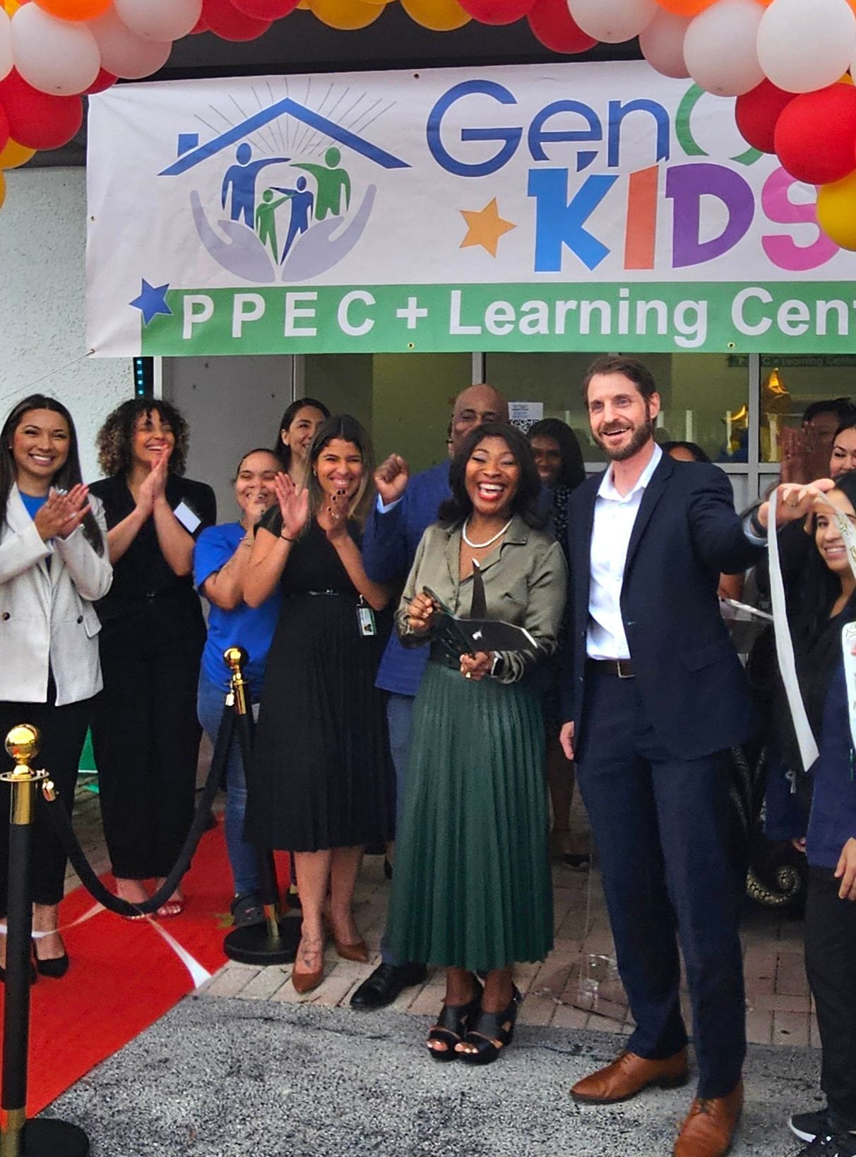 A group of people standing in front of a sign that says gen kids learning center