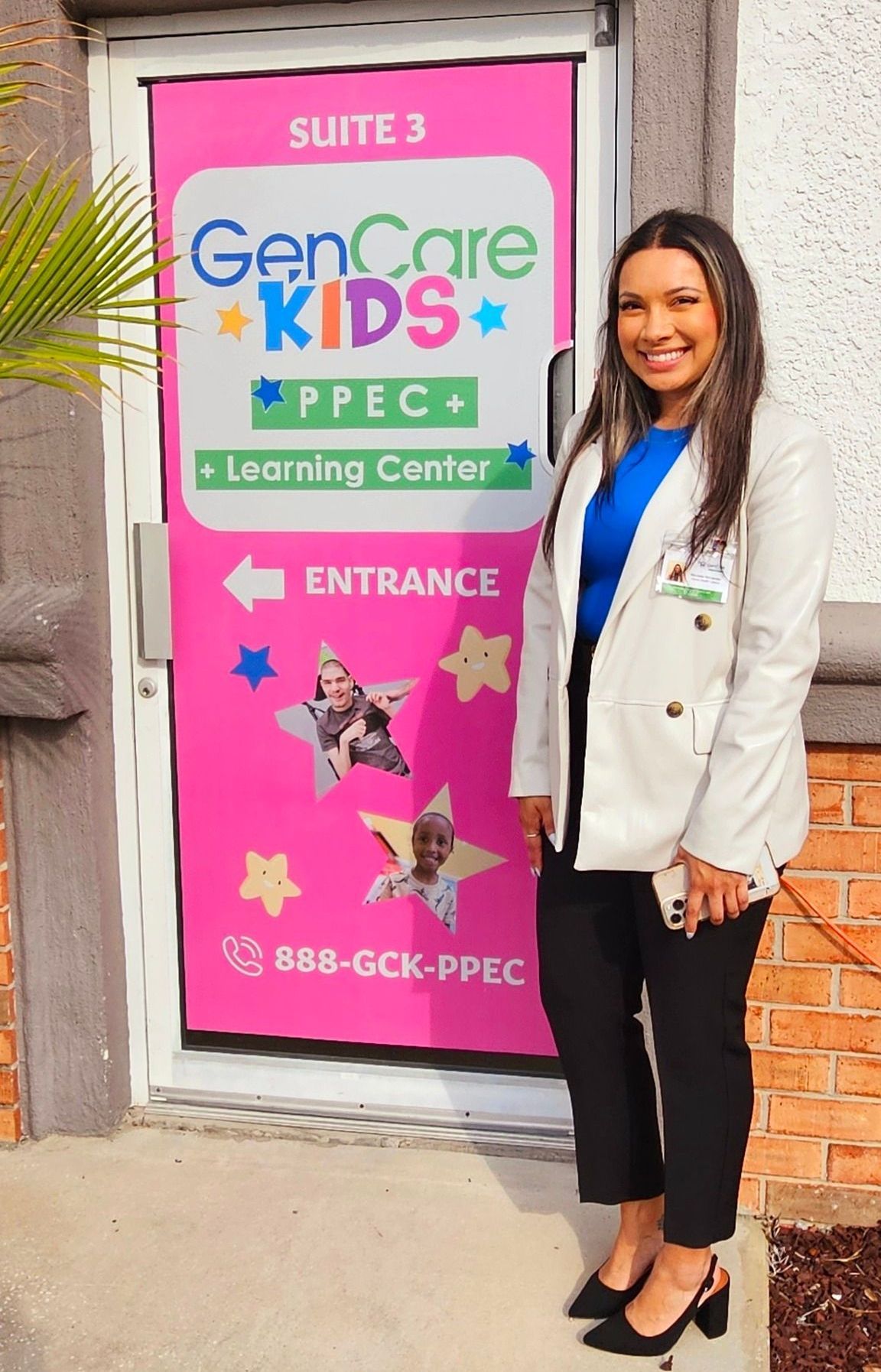 A woman is standing in front of a pink door.