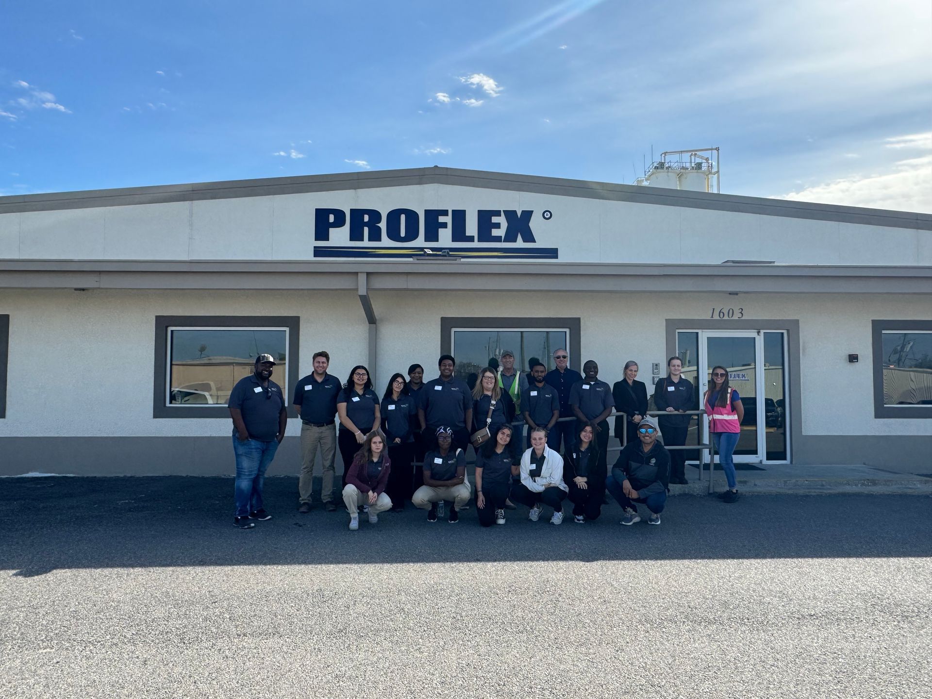 A group of people are posing for a picture in front of a building.