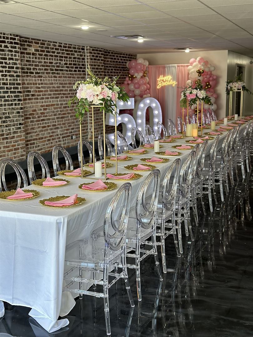 A long table and chairs are set up for a 50th birthday party.