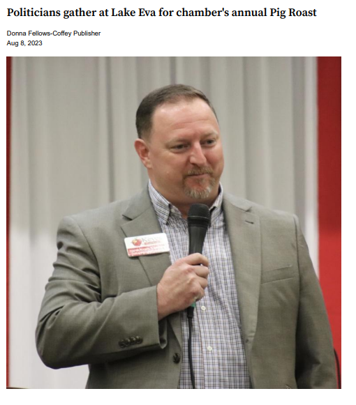 A man in a suit is speaking into a microphone