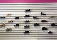 A row of shoes hanging on a wall in a store