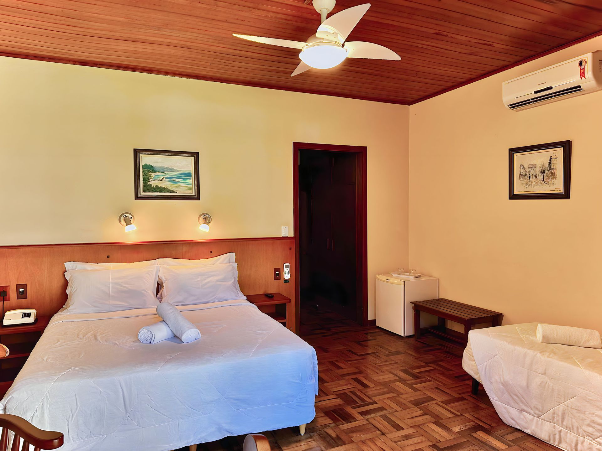 Um quarto de hotel com cama e ventilador de teto.