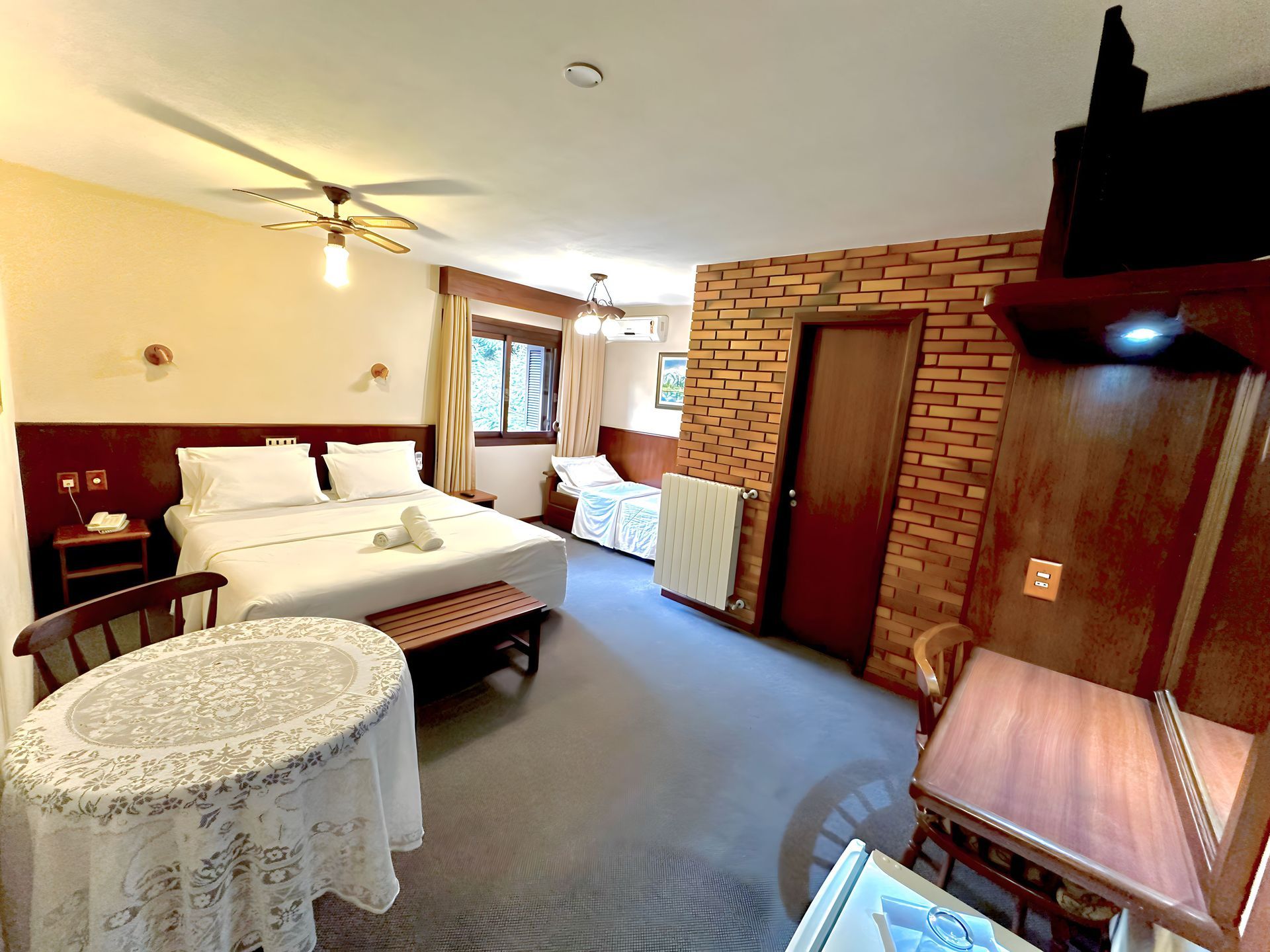 Um quarto de hotel com mesa e cadeiras e uma cama