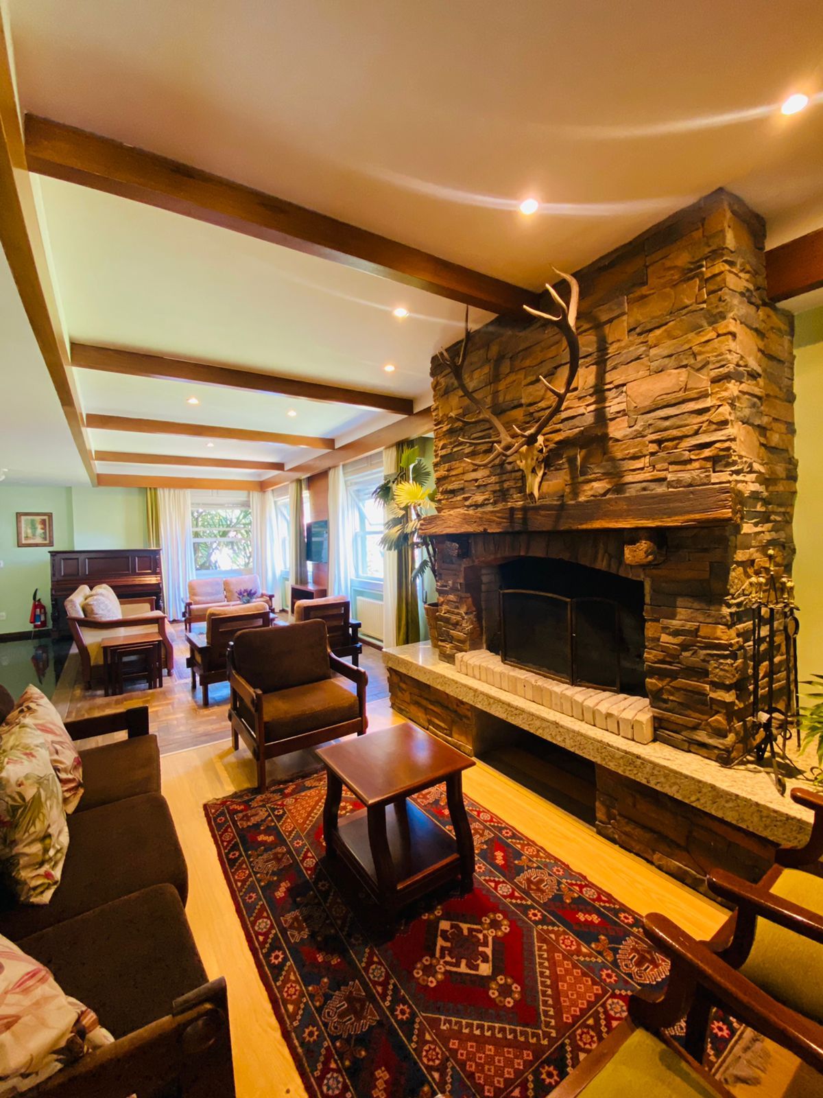 Uma sala de estar com lareira e sofá e cadeiras