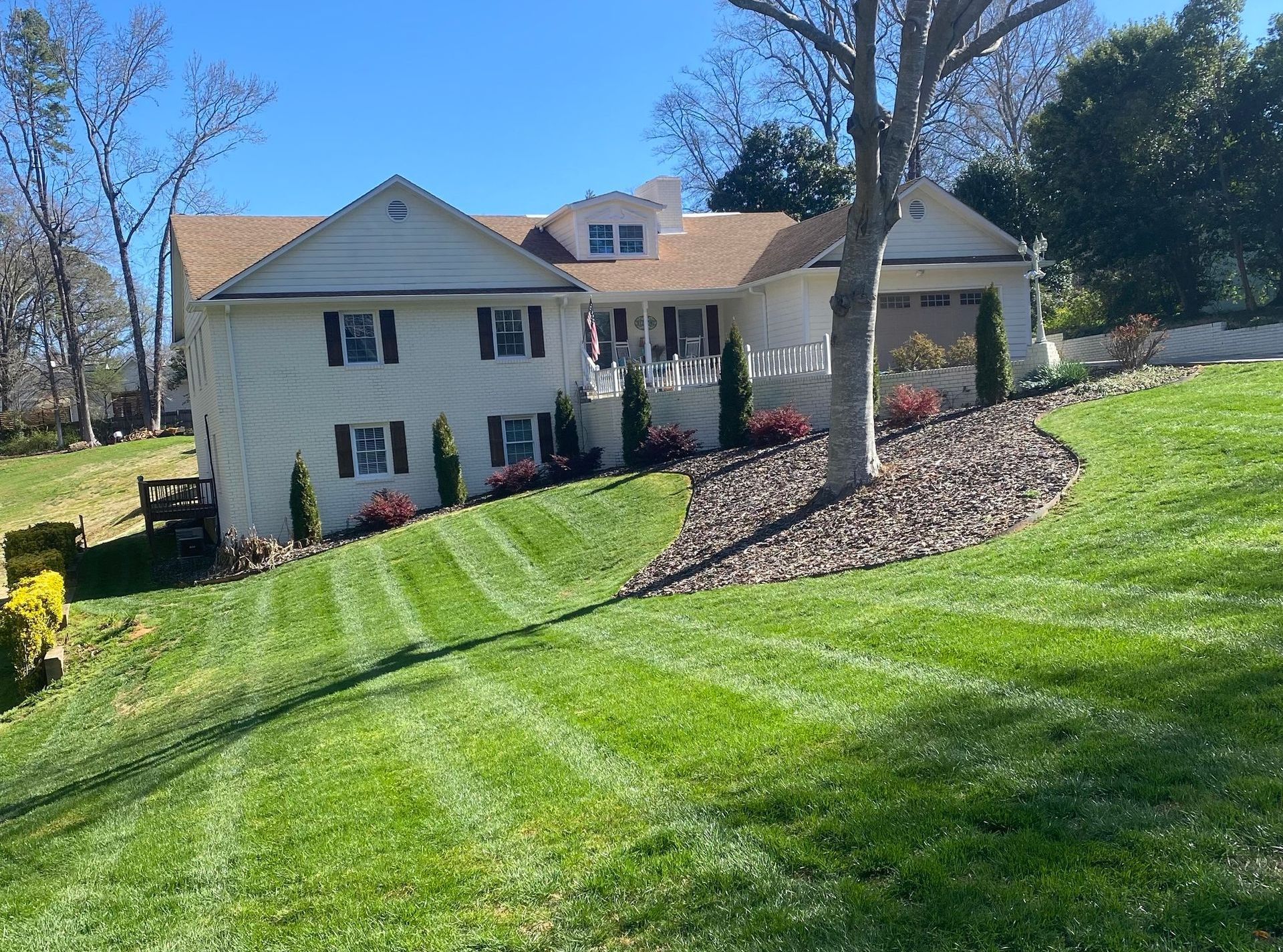 A large white house with a lush green lawn in front of it.