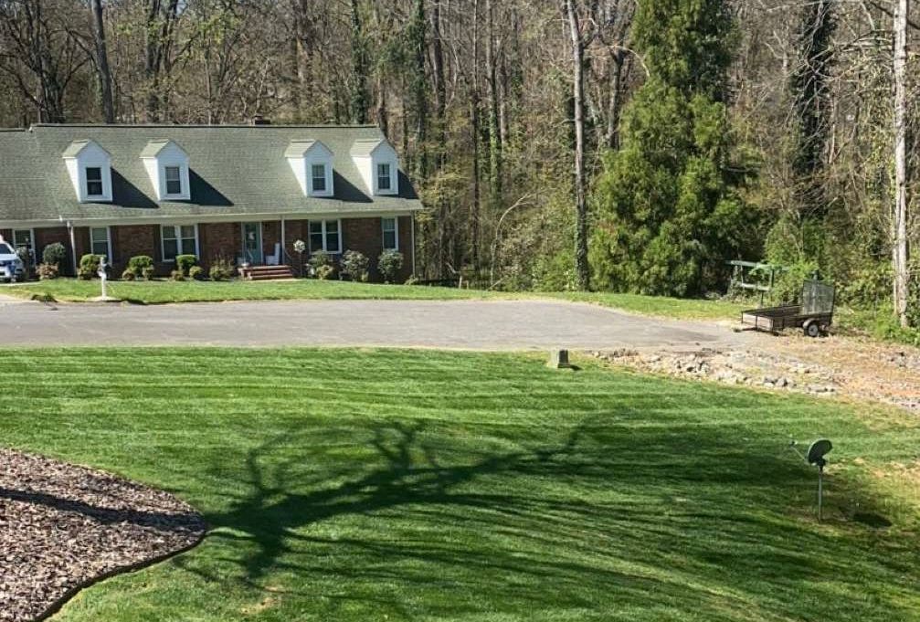 A house with a lush green lawn in front of it.