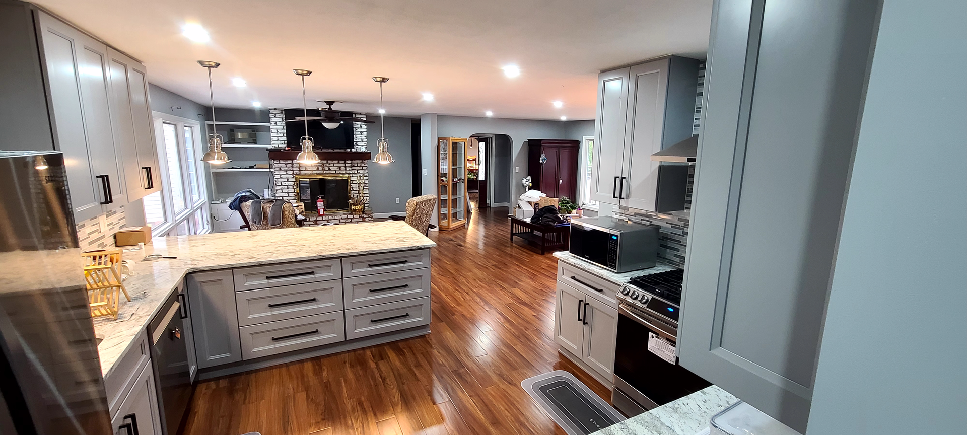 A kitchen with stainless steel appliances and a large island in the middle of the room.