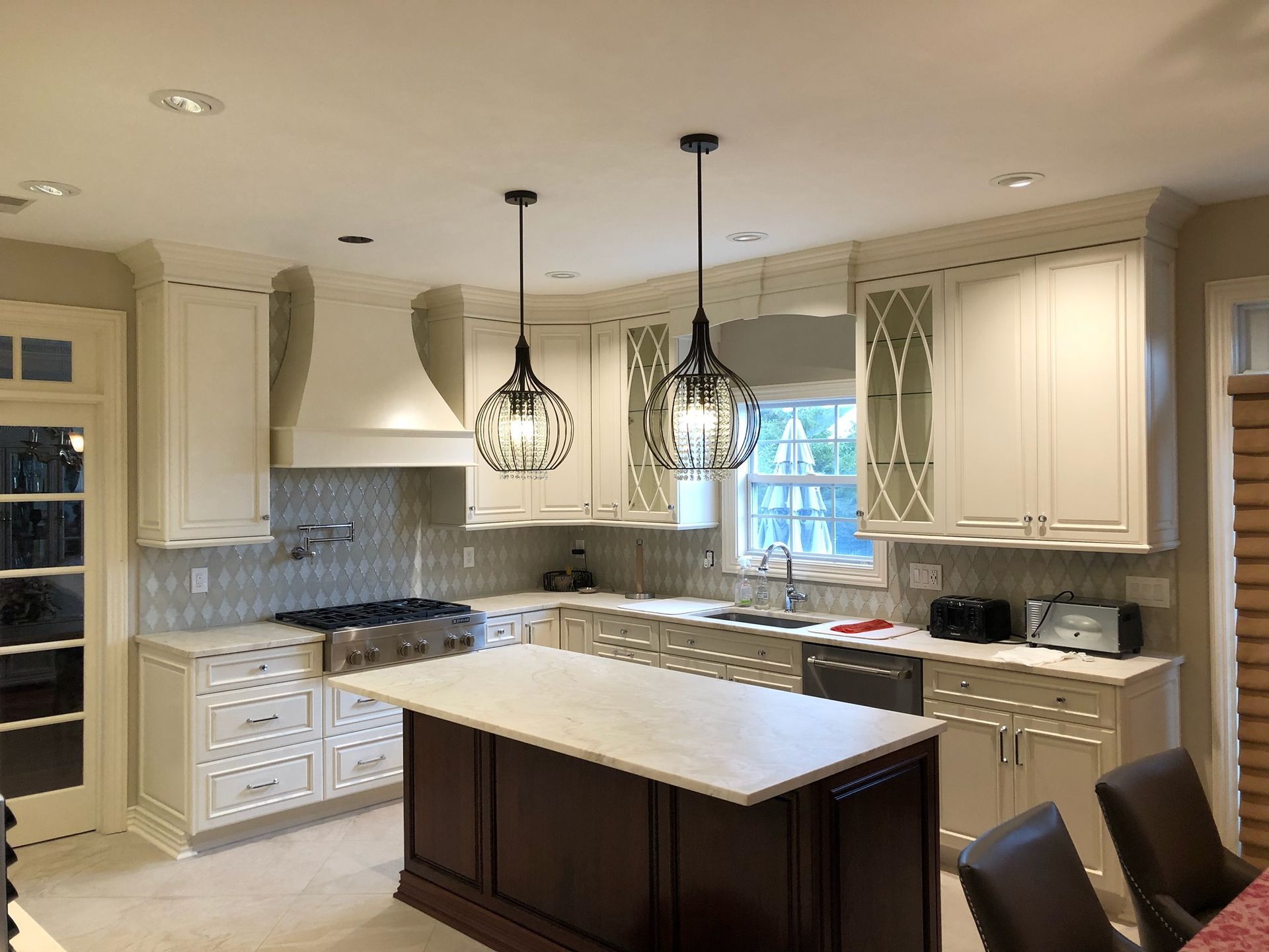 A kitchen with white cabinets and a large island