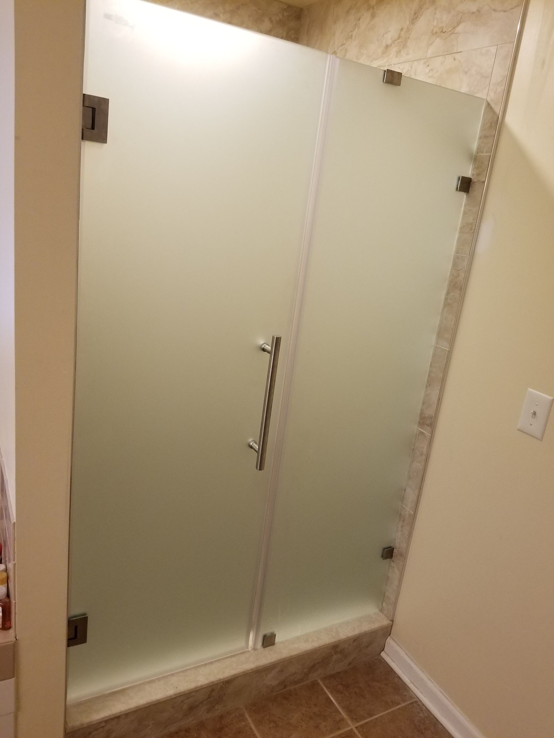 A bathroom with a frosted glass shower door.
