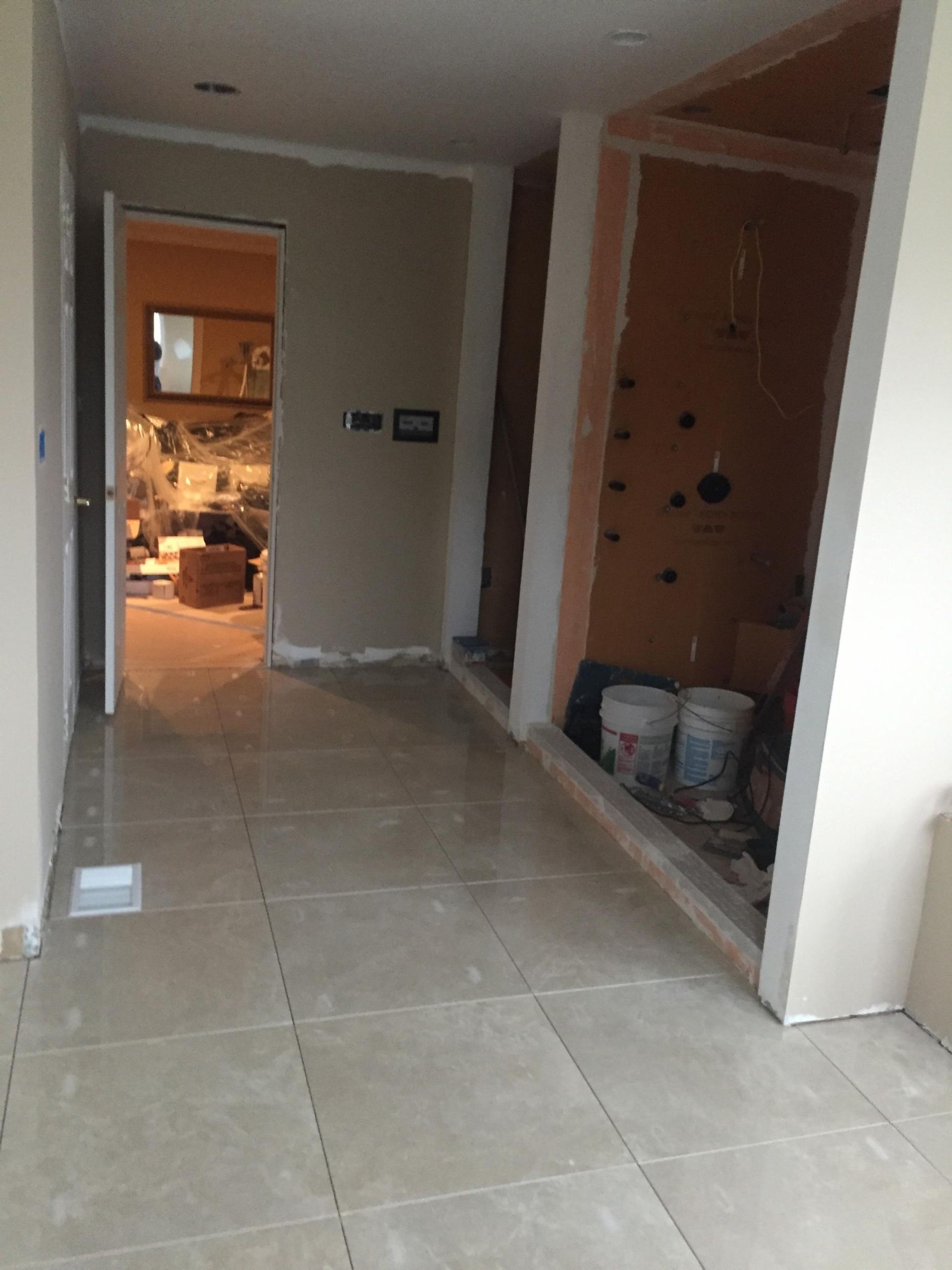 A hallway with buckets of paint on the floor