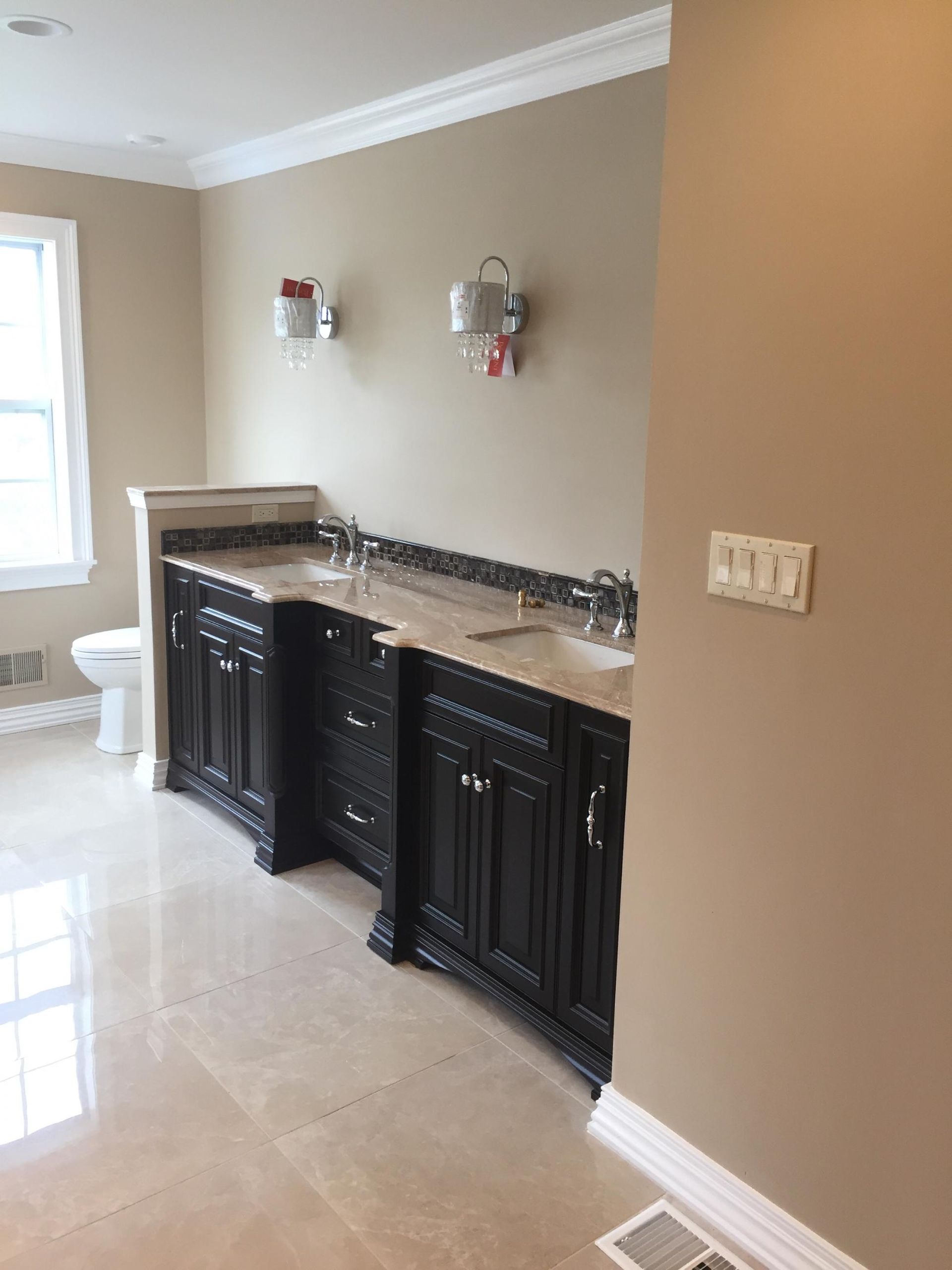 A bathroom with two sinks and a toilet