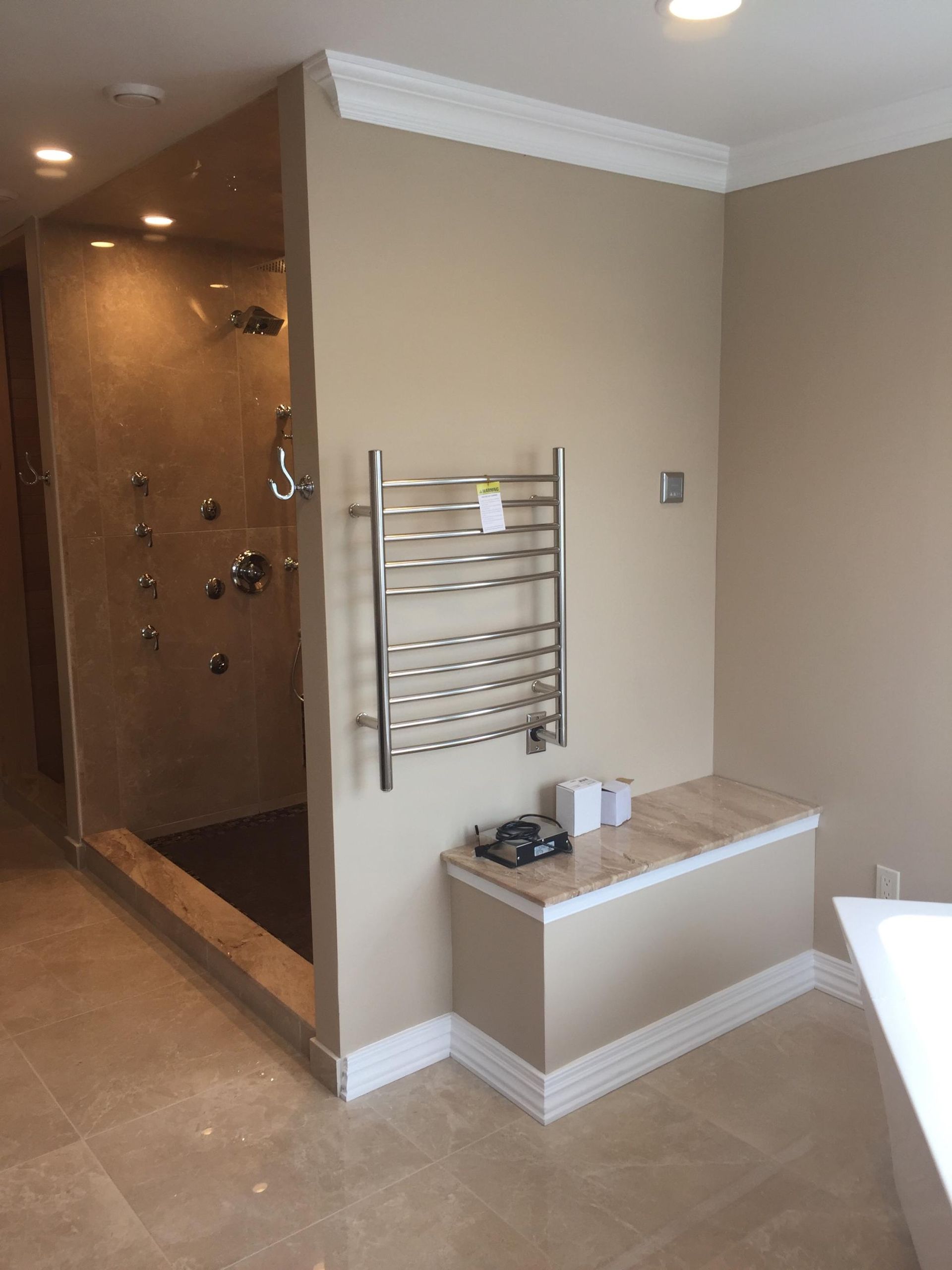 A bathroom with a walk in shower and a towel rack on the wall.