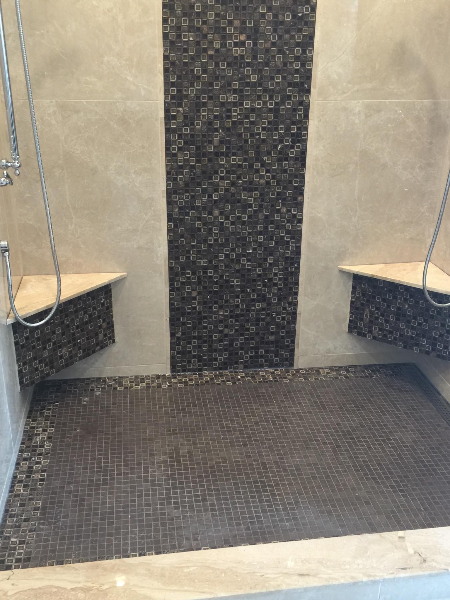 A shower with two benches and a tiled floor