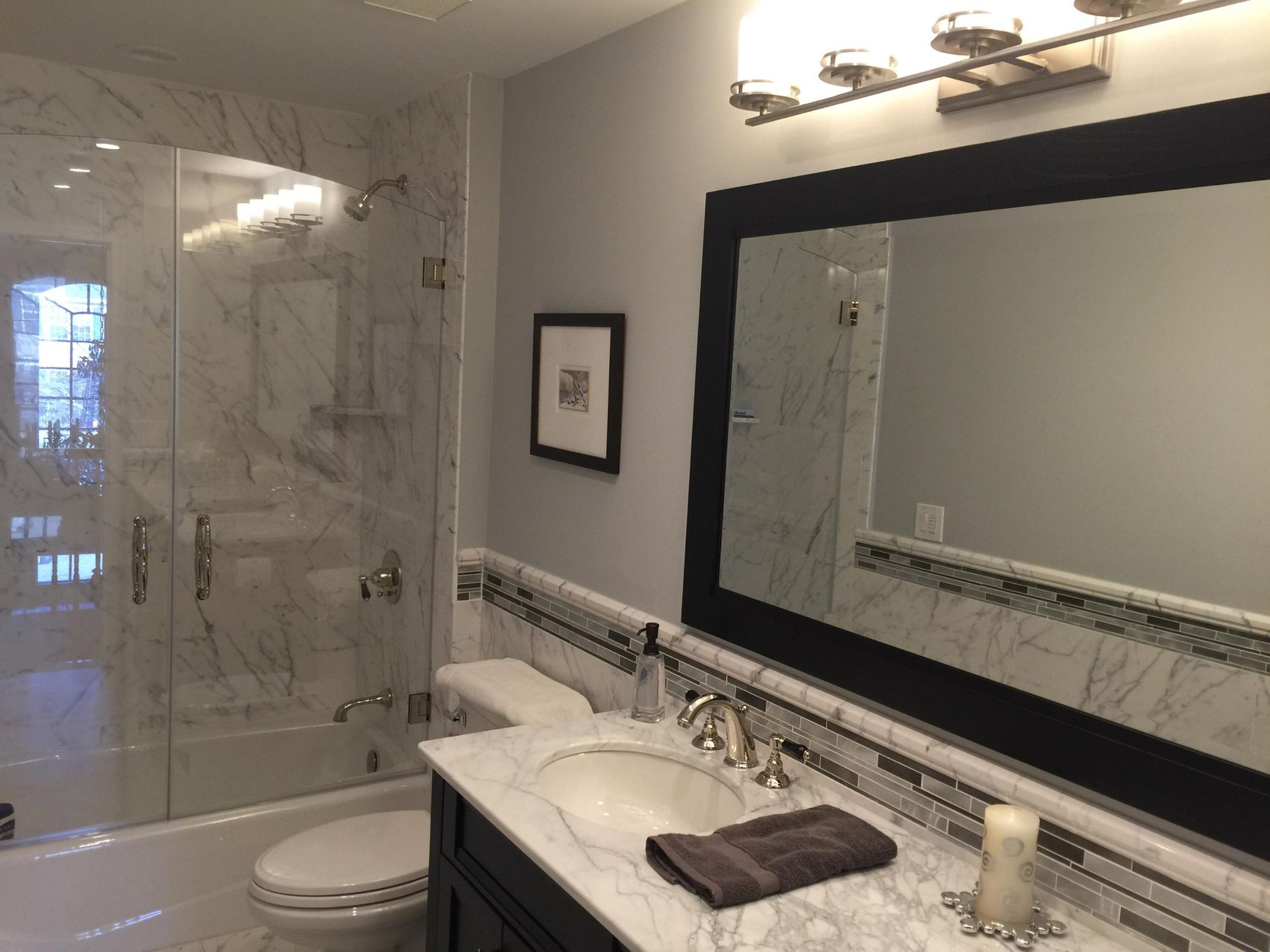 A bathroom with a toilet , sink , and mirror.