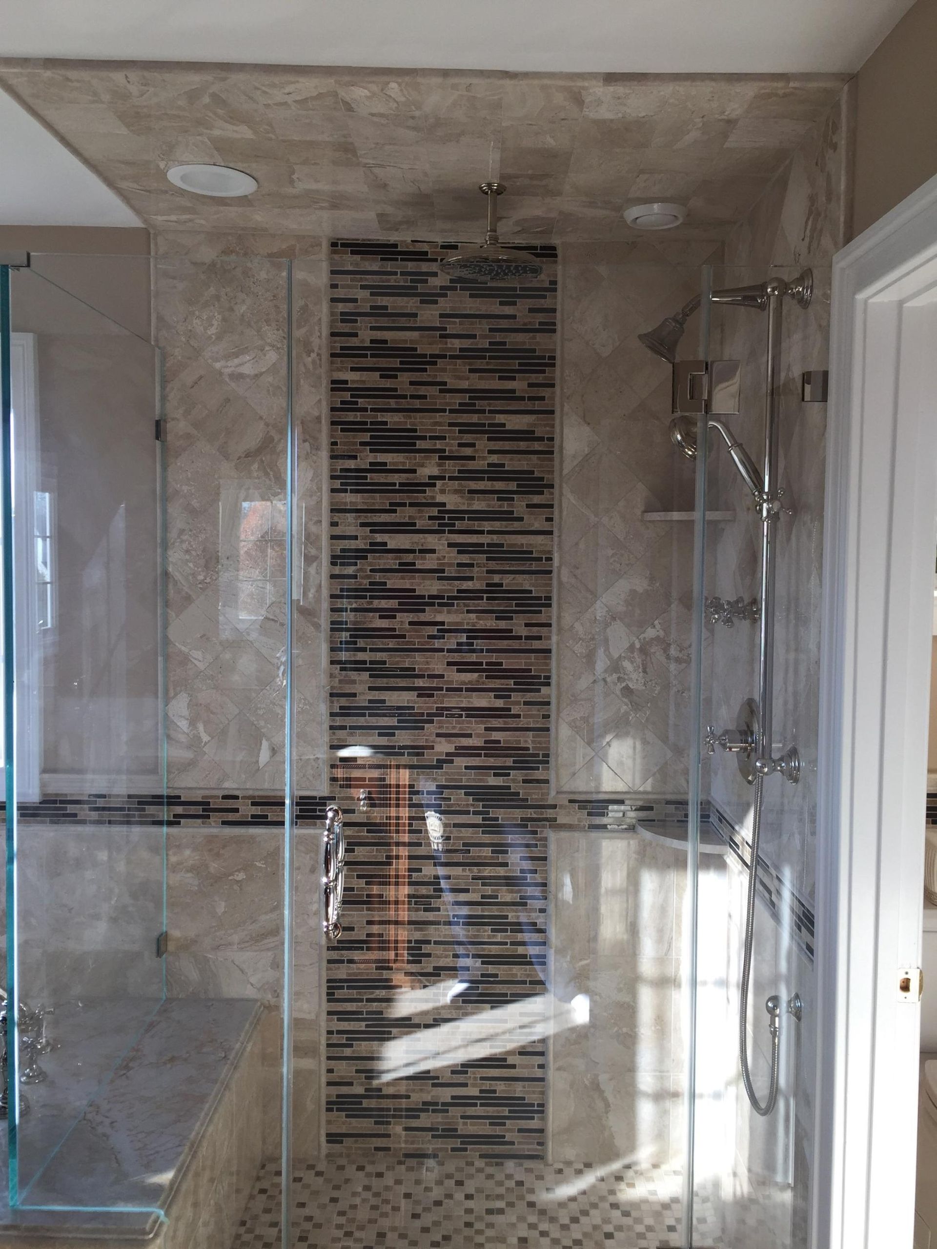 A bathroom with a walk in shower with a stone wall