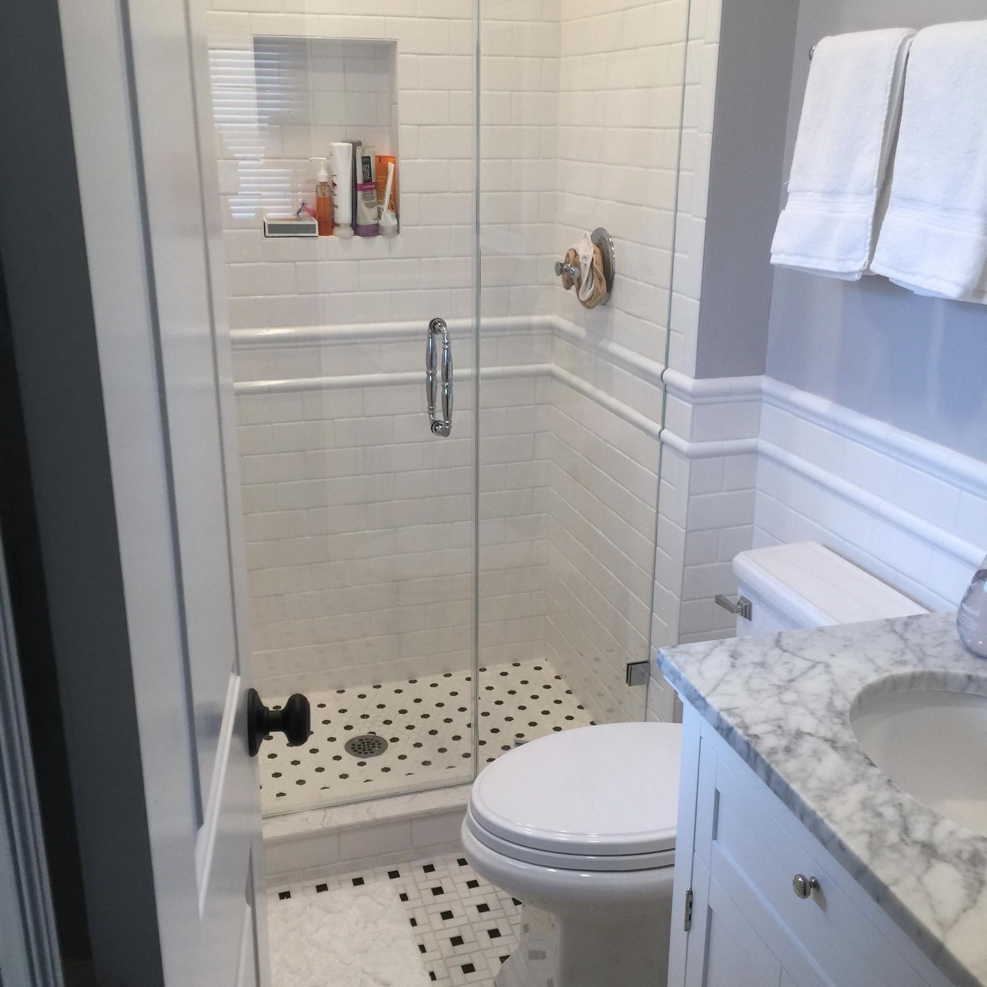 A bathroom with a toilet a sink and a walk in shower