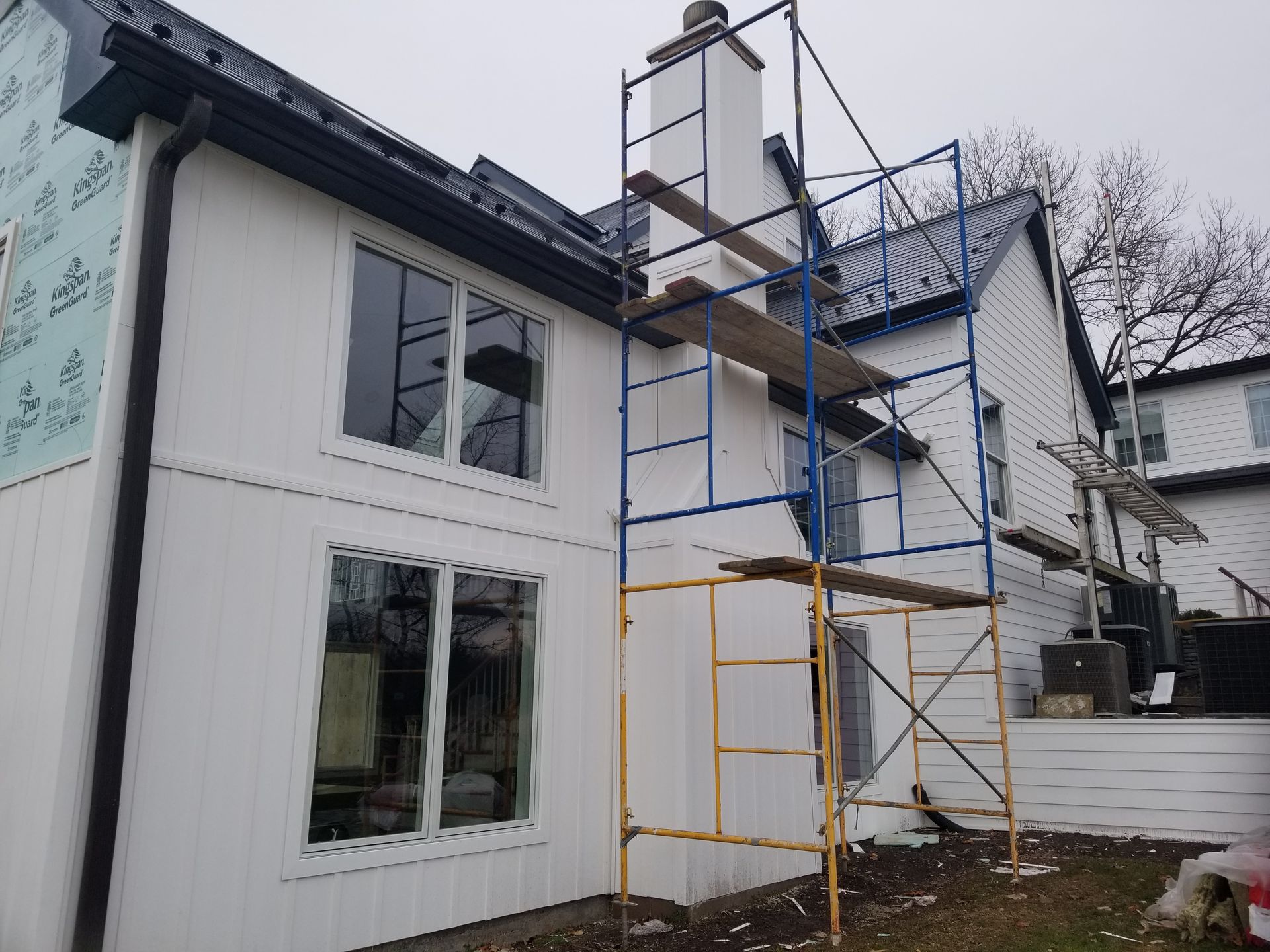 A white house with scaffolding on the side of it.