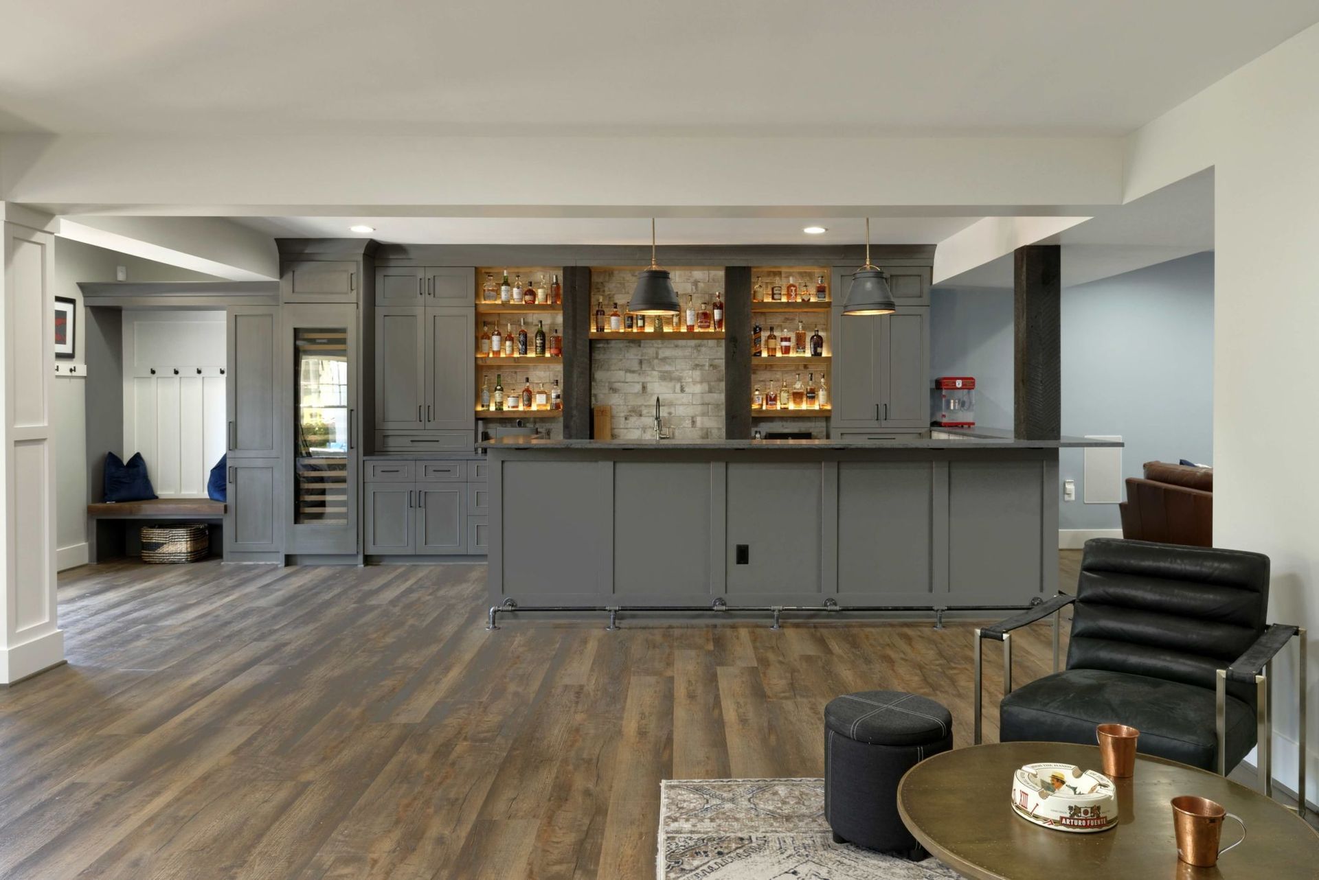 A living room with a bar , chairs and a table.