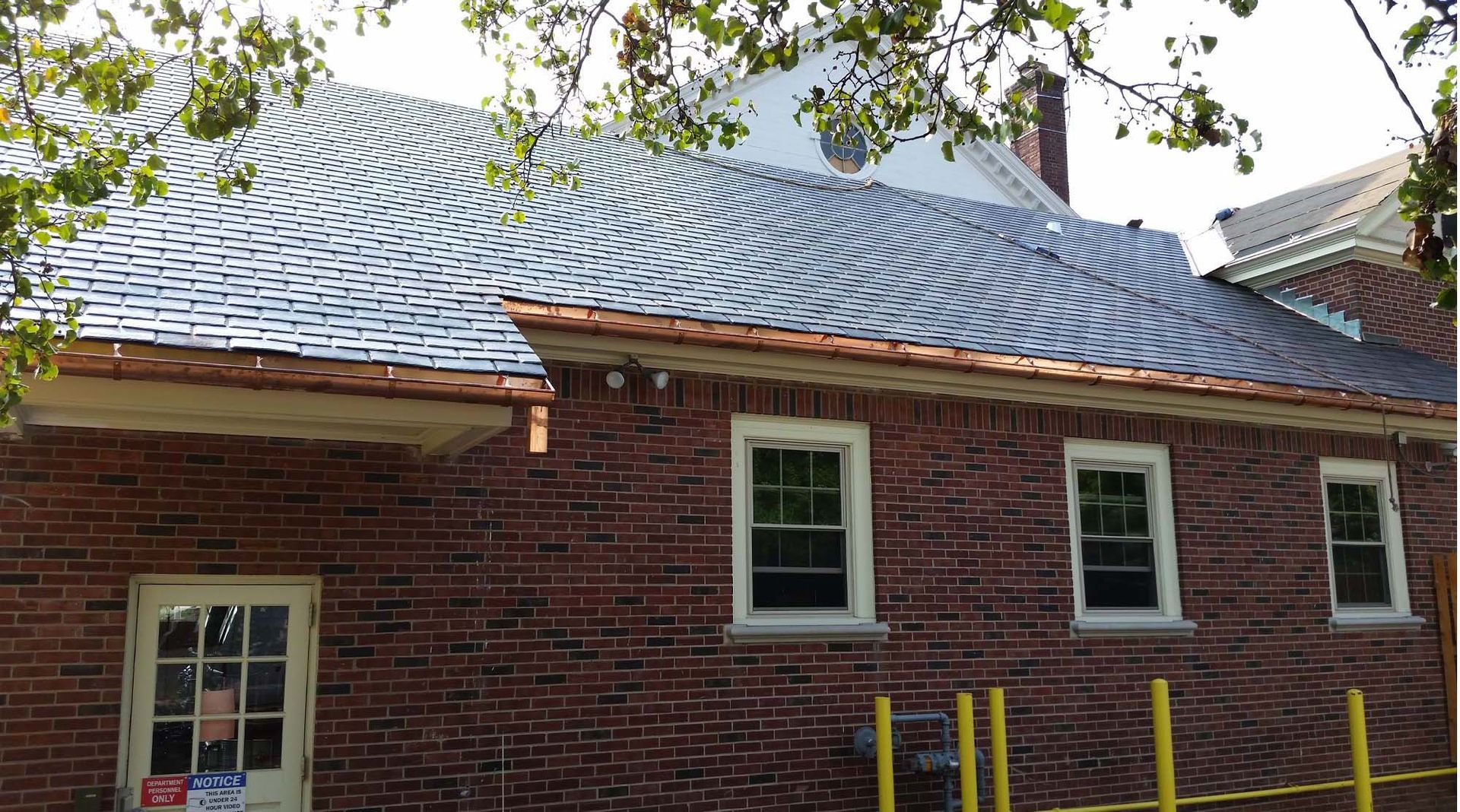 A brick building with a copper roof is being remodeled.