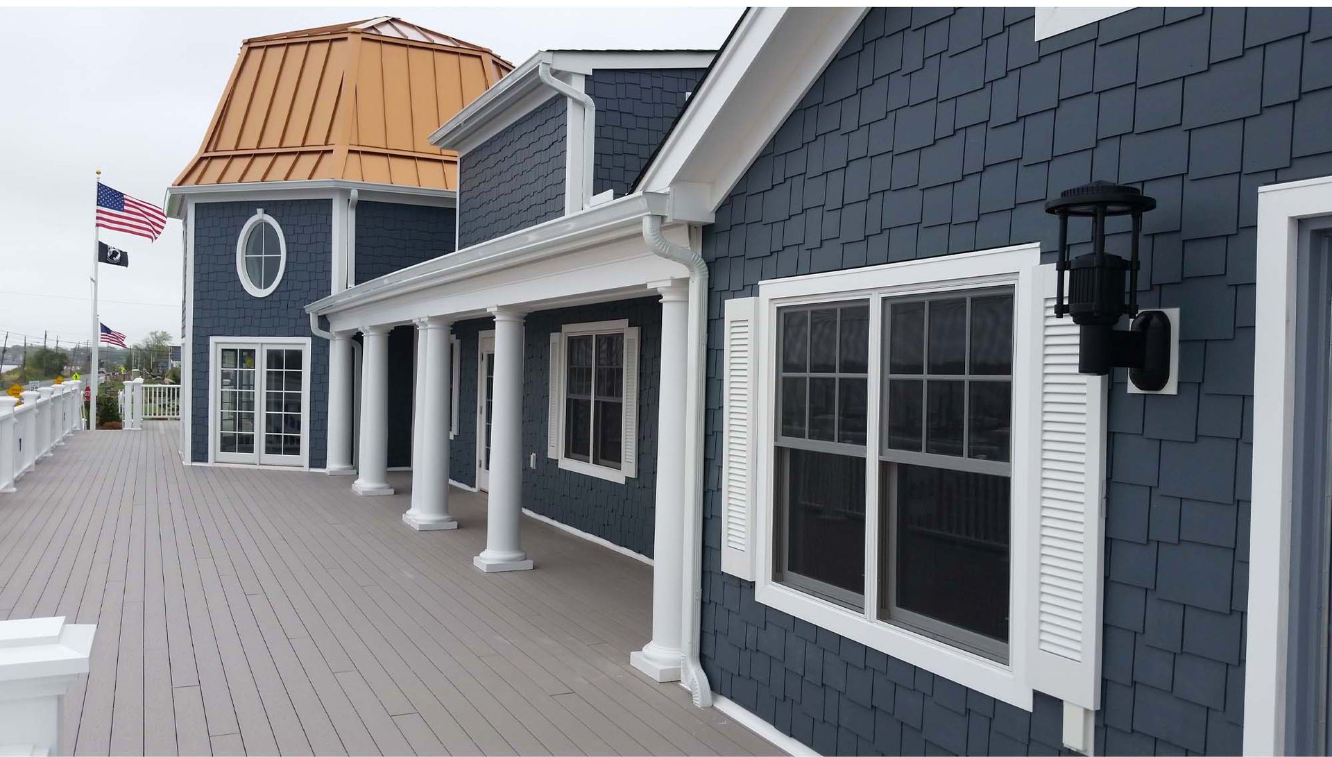 A blue house with white trim and shutters on the windows.