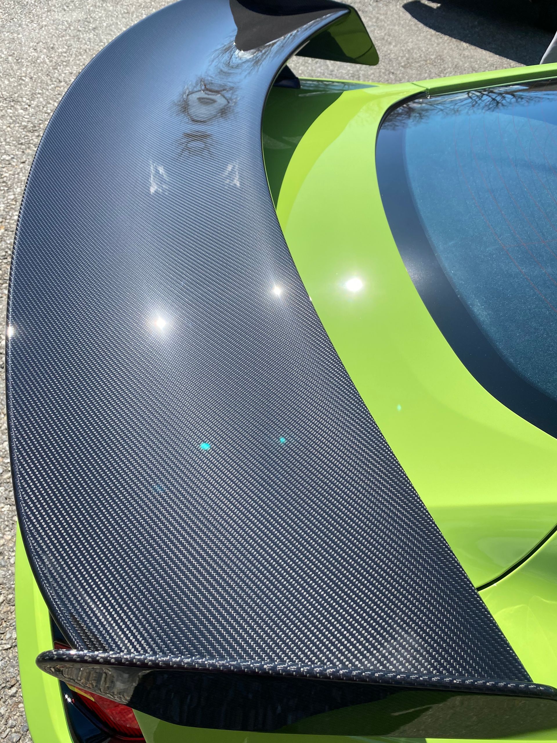 A close up of a green car with a black spoiler