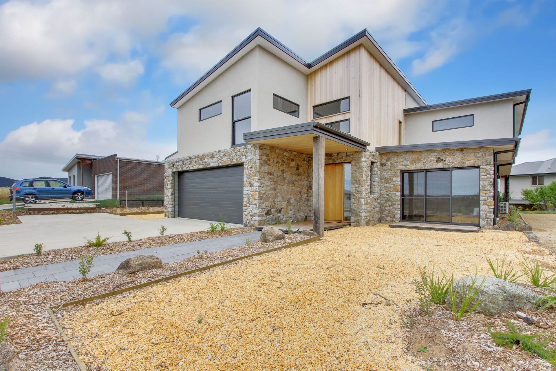 A brick house is being built on a lush green hillside.