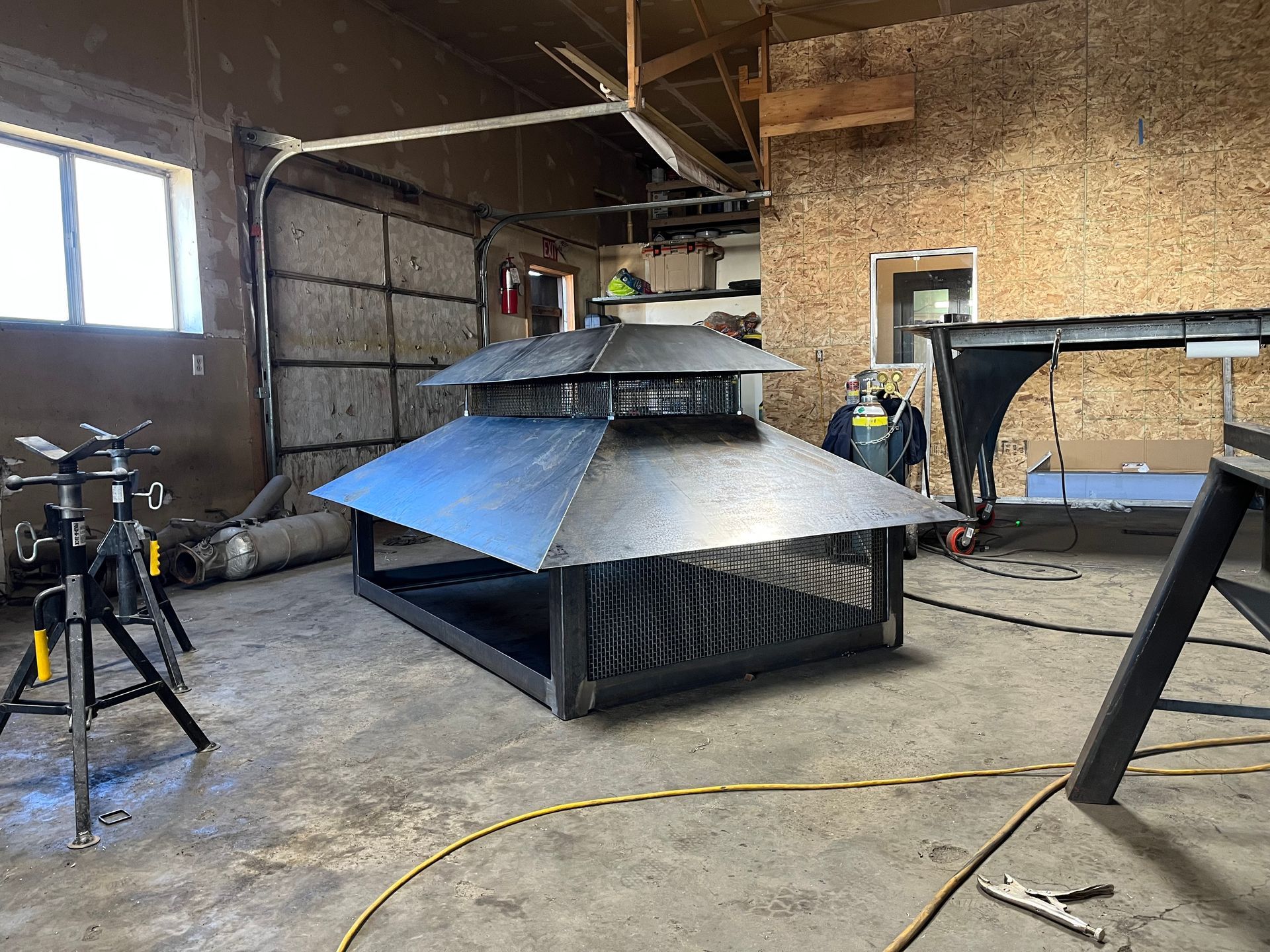 A large metal structure is being built in a garage.