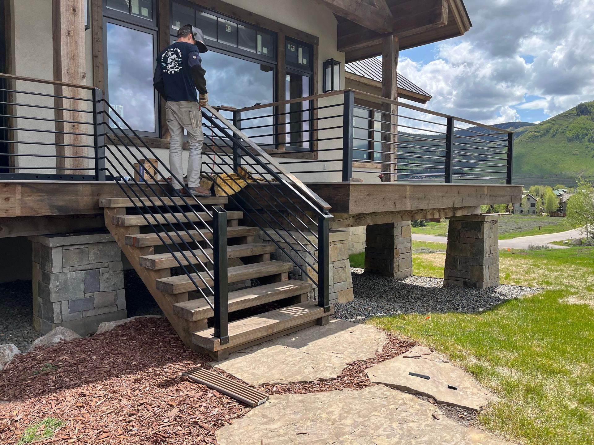 A man is standing on the stairs of a house.