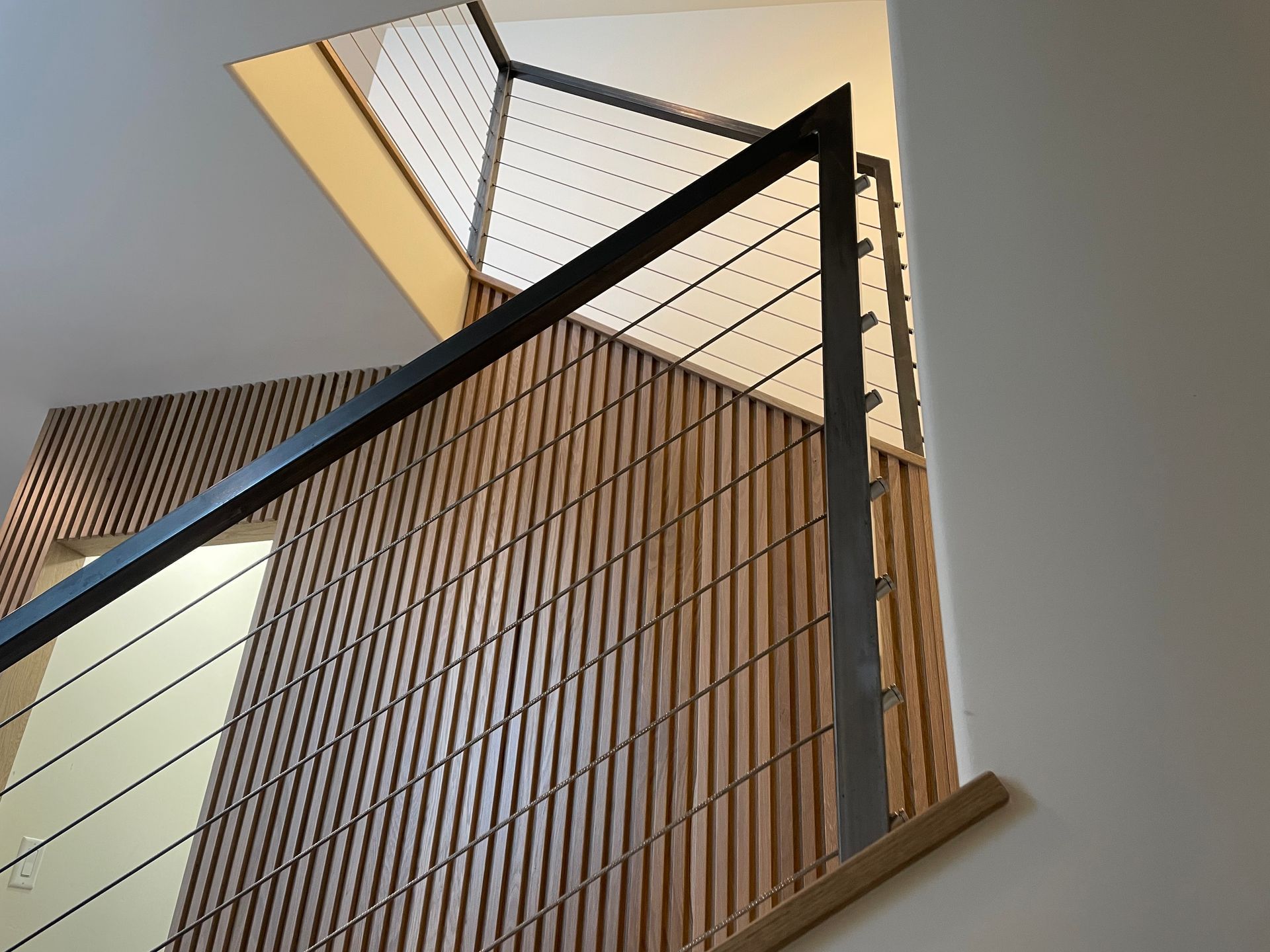 Looking up at a staircase with a wooden railing