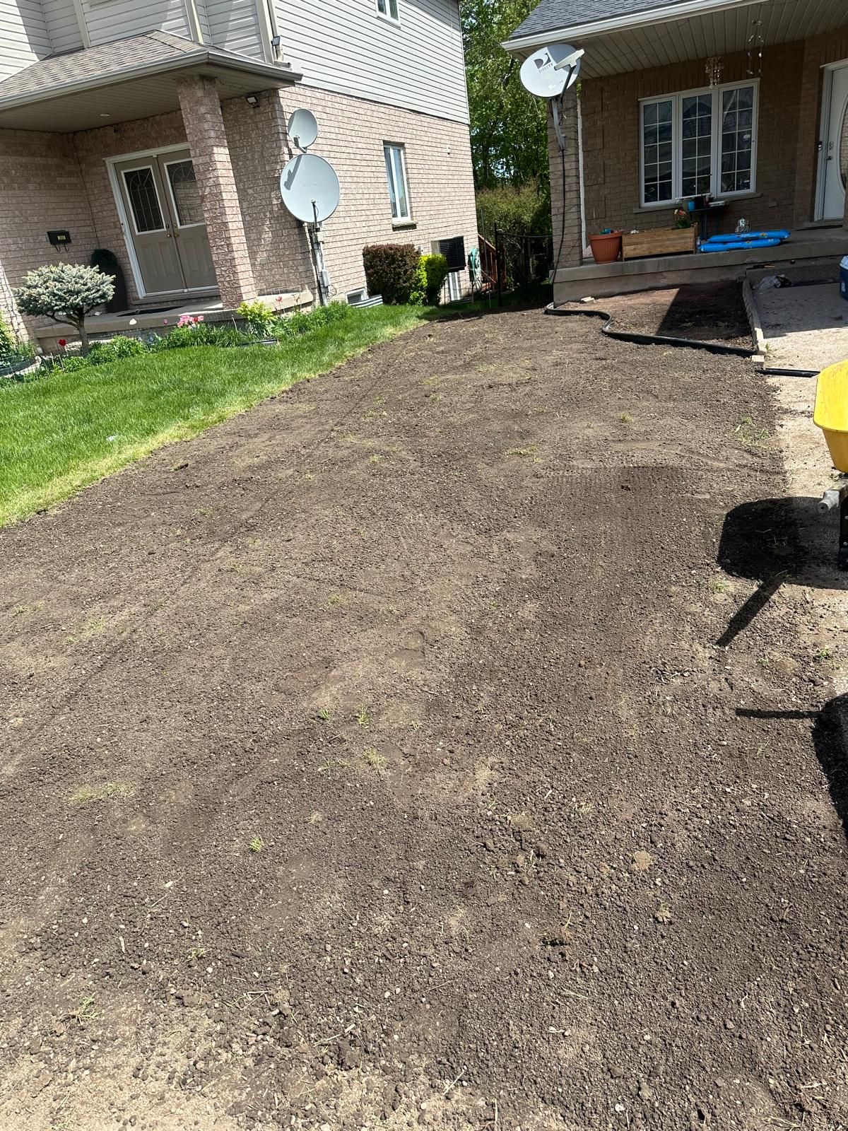 A large pile of dirt is sitting in front of a house.