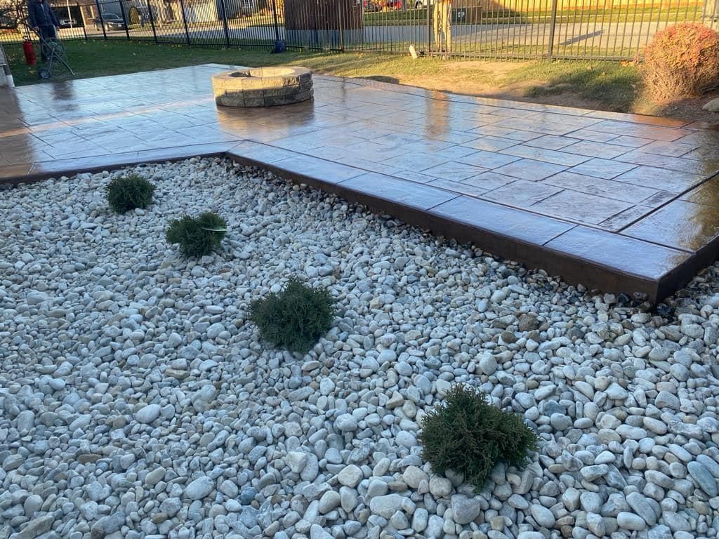 A concrete walkway is surrounded by gravel and plants.