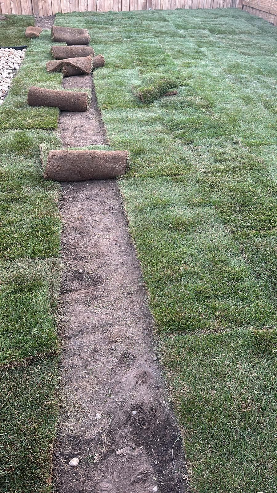 A row of turf rolls sitting on top of a lush green lawn.