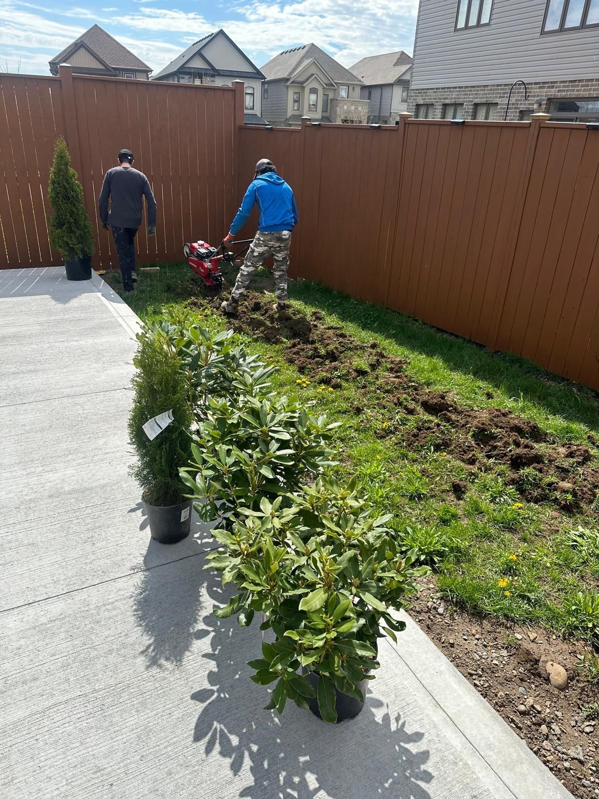 A man is using a lawn mower to cut the grass in a backyard.